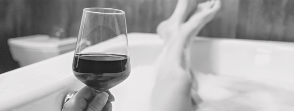 woman in bathtub with a glass of wine