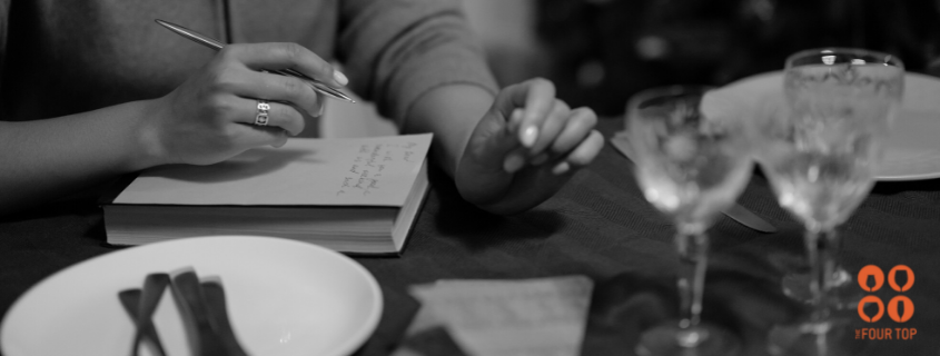 woman writing while drinking wine